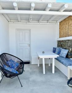 Zimmer mit einem Sofa, einem Tisch und einem Stuhl in der Unterkunft Mykonos Eight in Mykonos Stadt