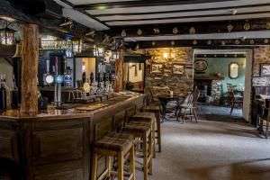 bar w pubie z drewnianymi stołkami w obiekcie White Hart Inn w mieście Bouth