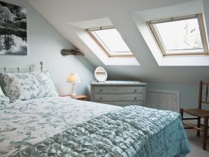 a bedroom with a bed and two skylights at Bowfell in Ambleside