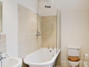 a bathroom with a tub and a toilet and a sink at Bowfell in Ambleside