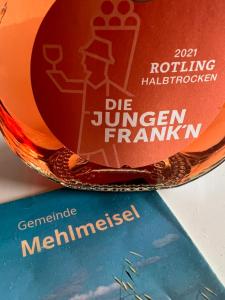 una botella de vino encima de un libro en Modernes Apartment “Traum“ en Mehlmeisel