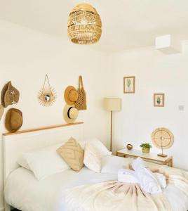 um quarto com uma cama com lençóis brancos e almofadas em Seafront Apartment em Portsmouth