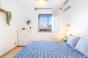 a bedroom with a blue bed and a window at 1ºlineaMar-exclusive-BBQ-wifi-Relax-PortAventura6 in Salou