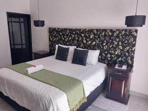 a bedroom with a large bed with a head board at The Guesthouse Klerksdorp in Klerksdorp