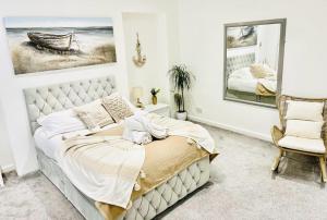 a bedroom with a bed and a chair at Seafront Apartment in Portsmouth