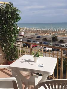 un tavolo su un balcone con vista sulla spiaggia di IL MARE DI ROMA APARTMENT a Lido di Ostia