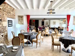 - un restaurant avec des tables et des chaises dans une salle dans l'établissement Hotel The Originals Le Manoir de Pierre Levée, à Tournon-Saint-Martin