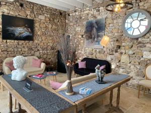 sala de estar con mesa y pared de piedra en Hotel The Originals Le Manoir de Pierre Levée en Tournon-Saint-Martin