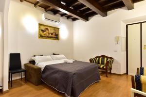 a bedroom with a bed and a chair at Elite Rome apartments 3 in Rome +5 photos