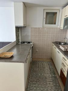 a small kitchen with white cabinets and a sink at Close to SCC Luxury apartment in Sarajevo in Sarajevo