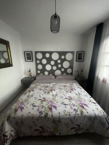 una camera da letto con un grande letto con un copriletto floreale di Apartamento 70 Vera Playa a Vera