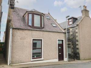 an old brick house with windows and a roof at RockStar Cottage in Macduff