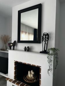 uno specchio sopra un camino con delle candele sopra di Apartamento 70 Vera Playa a Vera Altre 14 foto