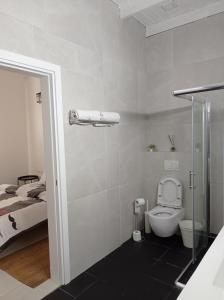 a white bathroom with a toilet and a bed at צימר ברחובות- Tara ארוח Tzimmer יש ממד במתחם in Rechovot