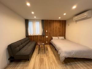 大阪市にある蝉時雨－大正のベッド2台とソファが備わる小さな客室です。