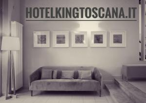 皮耶特拉桑塔的住宿－國王酒店，客厅配有沙发和墙上的标志