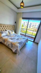 a bedroom with a bed and a large window at appartement haut standing en résidence Cabo Huerto vue sur deux grand Piscine in Cabo Negro