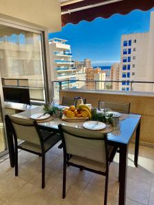 une table avec une assiette de fruits sur un balcon dans l'établissement ALCOTAN 2 Modern apartment with sea view & big sunny terrace, à La Cala de Finestra