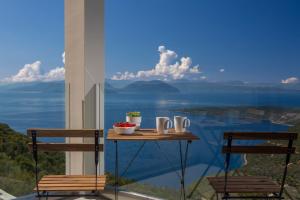 a table on a balcony with a view of the water at Heavenly Heights Villas in Évyiros