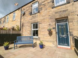 un banc bleu assis devant un bâtiment en briques dans l'établissement 19 Duke Street, à Alnwick