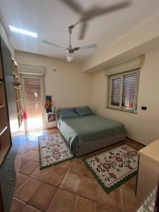 a bedroom with a bed and a ceiling fan at La casa nel villaggio dei pescatori in Spadafora
