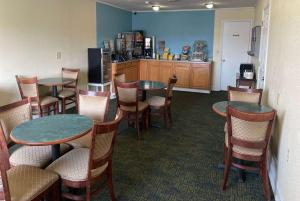 a restaurant with tables and chairs and a kitchen at Days Inn by Wyndham Hannibal in Hannibal