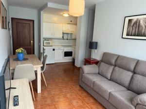 uma sala de estar com um sofá e uma mesa em Apartamentos Club Condal em Comillas