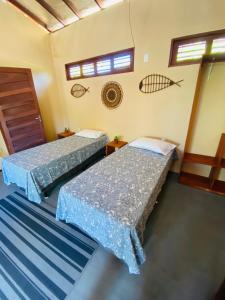 twee bedden in een kamer met twee ramen bij BeachResidence- KiteAliCori in Luis Correia