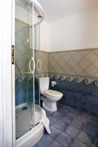 a bathroom with a toilet and a glass shower at Pension Kalmus in Smołdziński Las