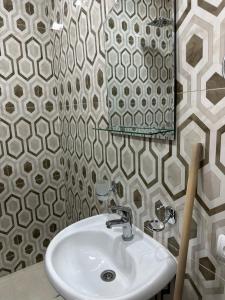 ein Bad mit einem Waschbecken und einem Spiegel in der Unterkunft Family Guest House in Yerevan