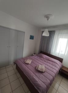 - une chambre avec un lit violet et 2 oreillers dans l'établissement Helena's Apartment 2 Agia Triada, à Thessalonique
