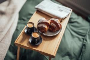 リエパーヤにある"AMBRA" by Pilatのテーブルの上にクロワッサンとコーヒーカップが置かれたトレイ