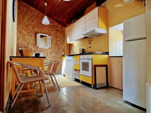 a kitchen with a white refrigerator and some chairs at Casa das Azenhas by Lisbon Village Apartments in Sintra