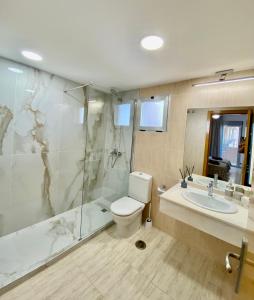La salle de bains est pourvue de toilettes, d'une douche et d'un lavabo. dans l'établissement ALCOTAN 2 Modern apartment with sea view & big sunny terrace, à La Cala de Finestra
