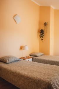 a room with two beds and a table with a lamp at Peniche Beach House in Peniche