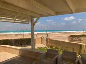 a view of the beach from the porch of a beach house at Maison sur plage in Al Ḩammām