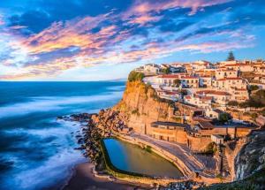 a village on top of a cliff next to the ocean at Casa das Azenhas by Lisbon Village Apartments in Sintra