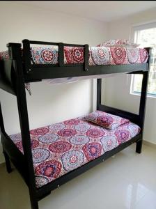 מיטה או מיטות קומותיים בחדר ב-Hermosa Casa con Aire Acondicionado y WI-FI