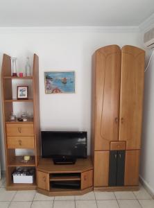 - un salon avec une télévision et une armoire en bois dans l'établissement Helena's Apartment 2 Agia Triada, à Thessalonique