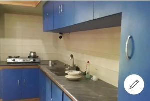 a kitchen with blue cabinets and a sink at Aminvilla resort - family stay to explore Sylhet in Sylhet +27 photos