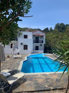 a villa with a swimming pool and a house at Skopelos Inn in Stafylos