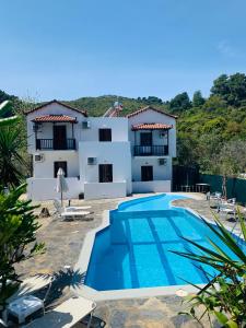 a villa with a swimming pool and a house at Skopelos Inn in Stafylos