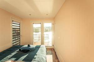 - une chambre avec un lit et une grande fenêtre dans l'établissement Hausboote am Bärwalder See Traumhaus-mieten, à Klitten