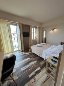 a bedroom with a bed and a desk with a chair at Don Ugo Luxury Rooms in Tropea