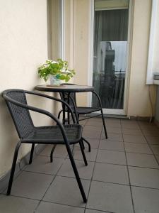 a table and chairs on a balcony with a plant at Rukadel - Poleska in Wrocław