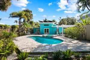 a blue house with a swimming pool in a yard at The Ringling Beach House in Siesta Key