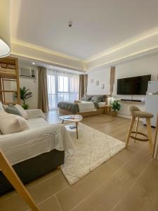 een grote woonkamer met 2 bedden en een televisie bij nJoy! BOHO Luxury at Venice Grand Canal - perfect for business & couples in Manilla