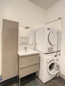 a small kitchen with a washing machine and a sink at Grand Appartement Paris et Disneyland 4pers in Neuilly-sur-Marne