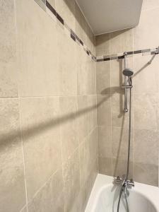 a bathroom with a shower with a white tub at Grand Appartement Paris et Disneyland 4pers in Neuilly-sur-Marne