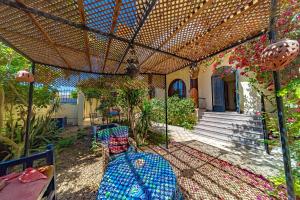 a person sitting under a pergola in a garden at Villa Bahri Luxor Apartment in Luxor